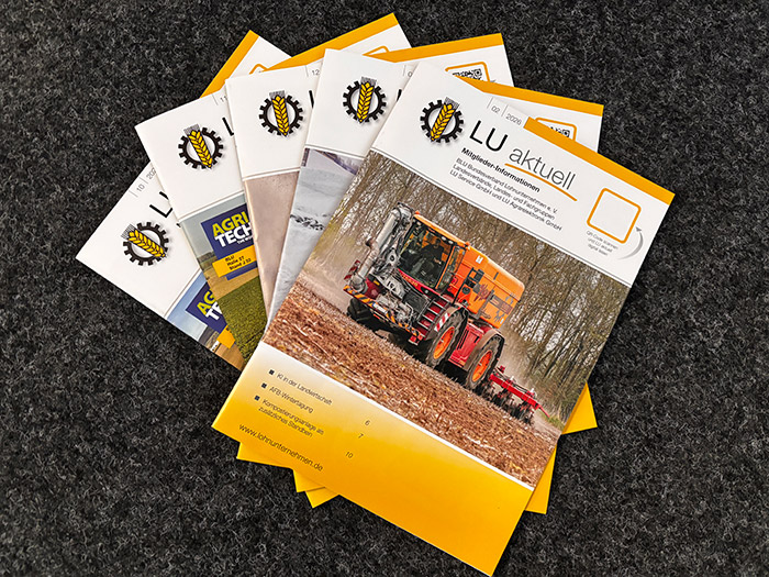 Ein Stapel landwirtschaftlicher Zeitschriften mit gelbem Einband auf einer grauen Fläche.