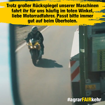 Ein Motorradfahrer fährt im toten Winkel eines Lkw, gesehen im Rückspiegel des Lkw.