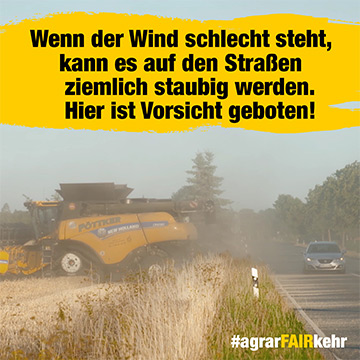 Ein Mähdrescher erzeugt bei der Feldarbeit viel Staub neben einer Landstraße; Autos fahren vorbei.