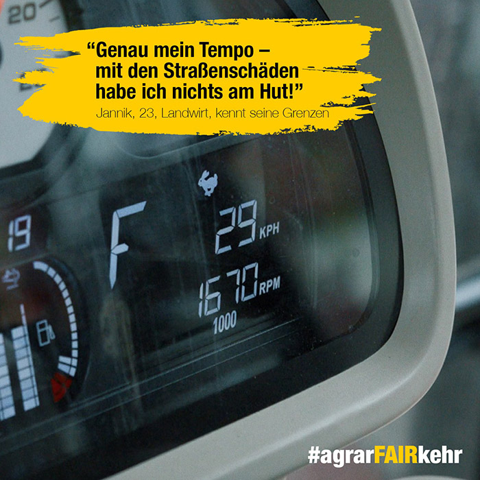 Nahaufnahme eines Traktor-Armaturenbretts mit 29 KPH; deutscher Text über Straßenschäden und Hashtag #agrarFAIRkehr.