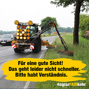 Ein Traktor mäht Gras neben einer Straße; ein gelbes Schild bittet um Geduld und Verständnis für die langsame Arbeit.