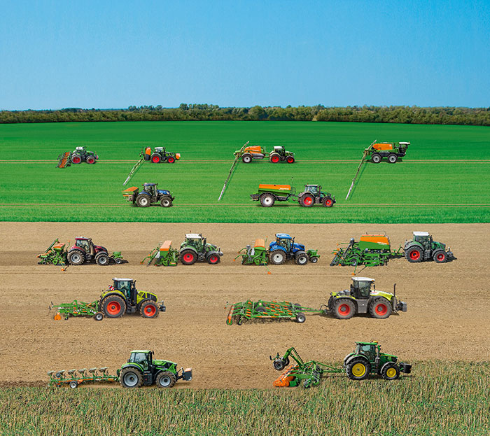 Mehrere Traktoren und landwirtschaftliche Geräte arbeiten in Reihen auf grünen und braunen Feldern unter einem klaren blauen Himmel.