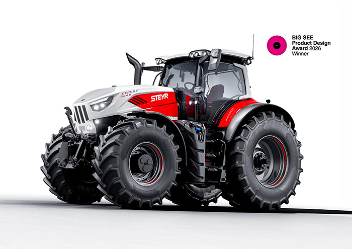 Ein moderner rot-weißer Steyr-Traktor mit großen Reifen, daneben ein Emblem des Produktdesignpreises 2026.